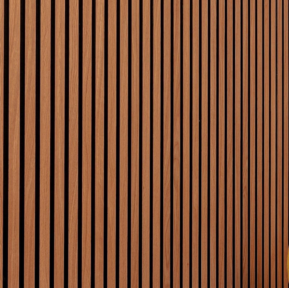 Sharp close-up of warm walnut-tone vertical slatted wall panel with dark grooves