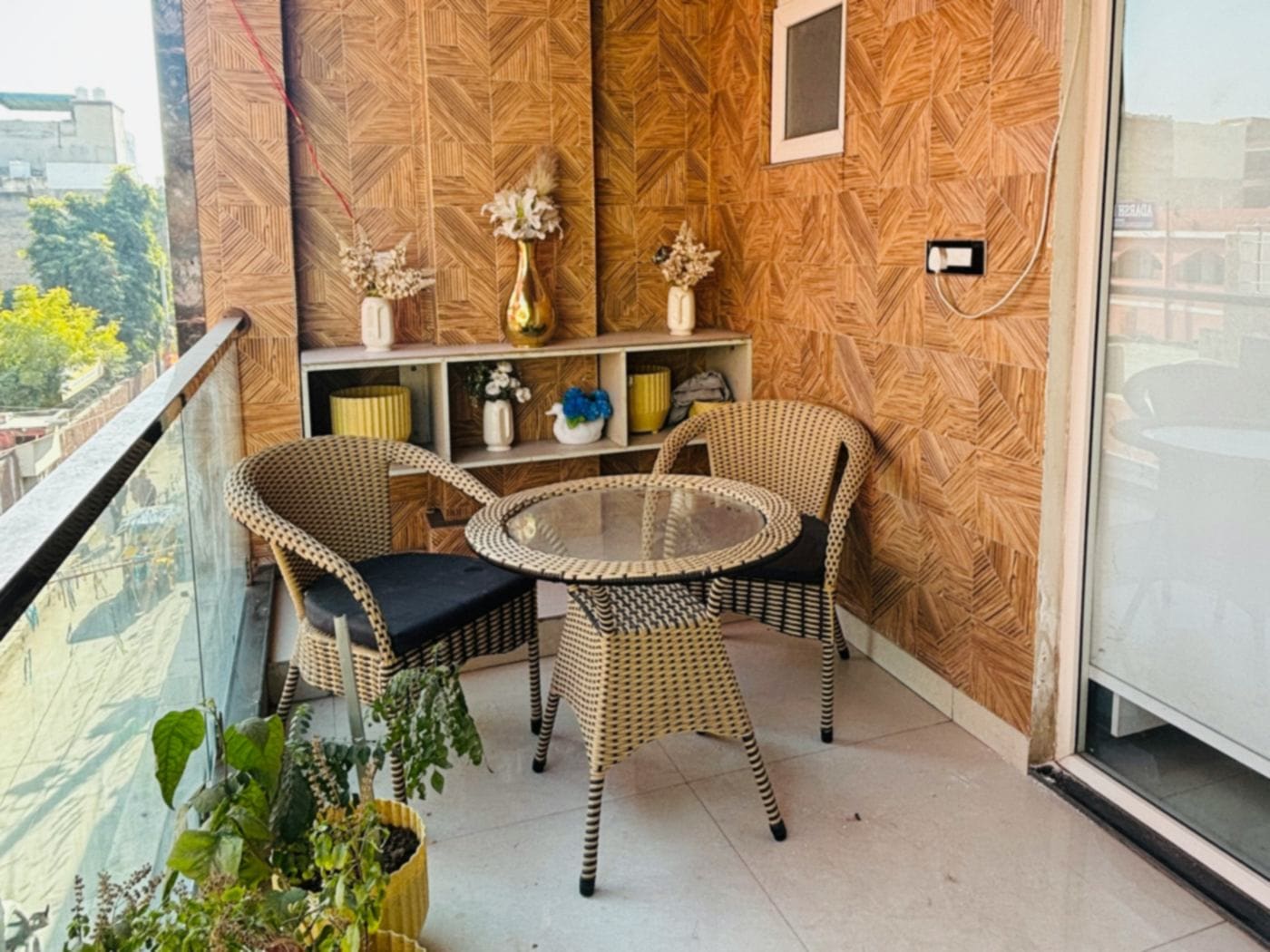 Indian apartment balcony with wood-plank ceiling, patterned wall cladding, rattan chairs and potted plants