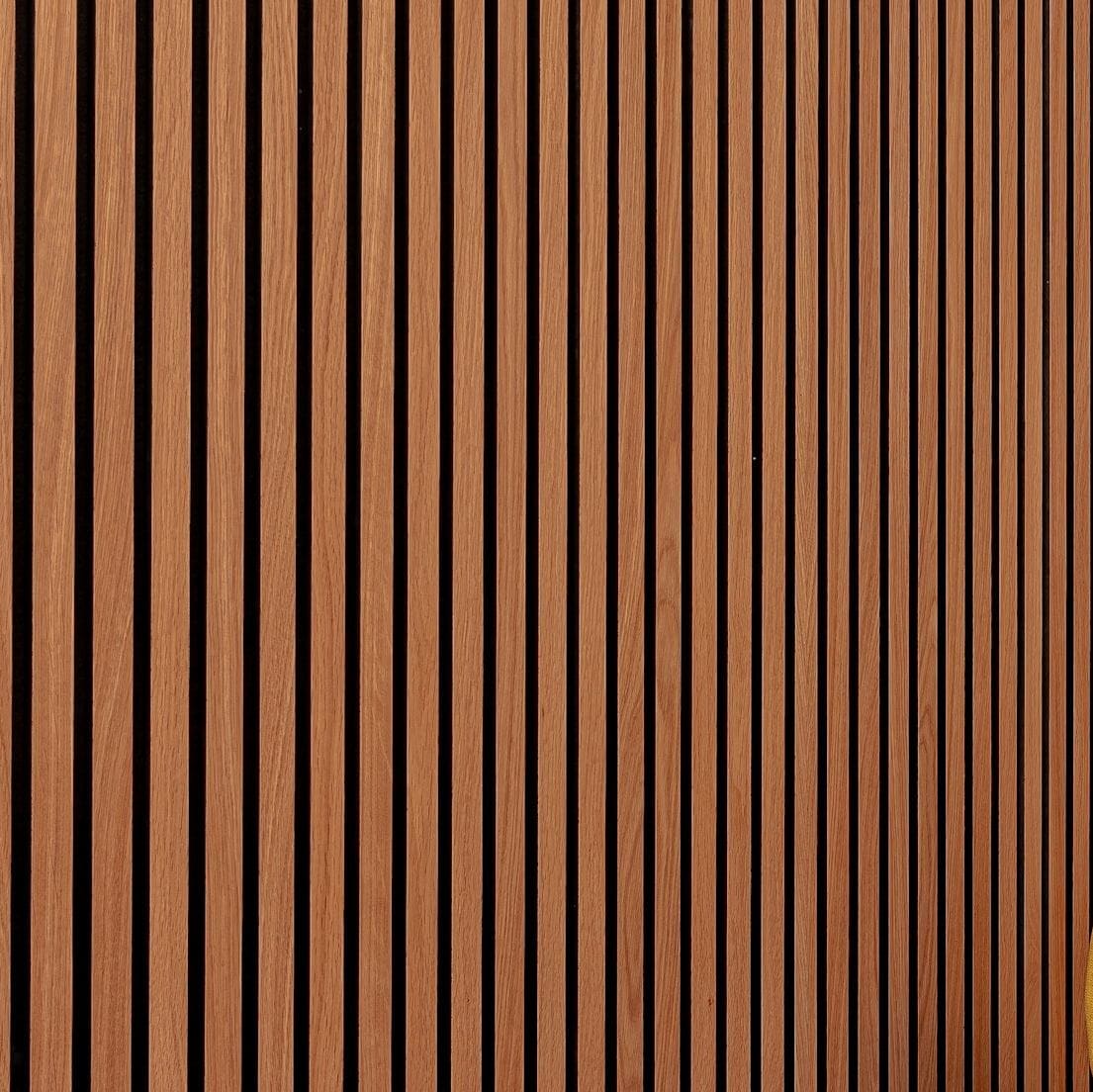 Sharp close-up of warm walnut-tone vertical slatted wall panel with dark grooves
